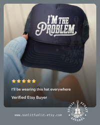 Thumbnail for A person is holding a navy blue baseball cap with the text 