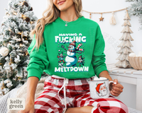 Thumbnail for A woman wearing a green sweatshirt with a humorous snowman graphic and the text 