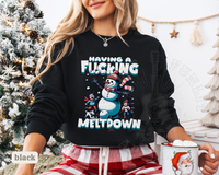 Thumbnail for A woman wearing a black sweatshirt with a graphic design of a snowman and the text 