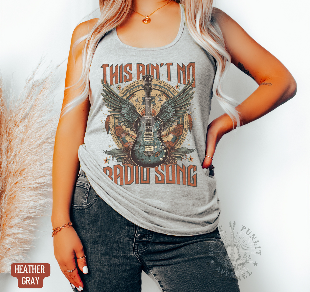 A woman wearing a gray tank top with a graphic design of a guitar and the text "This Ain't No Radio Song" printed on it.