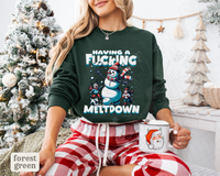 Thumbnail for A woman wearing a green sweatshirt with a snowman graphic and the text 