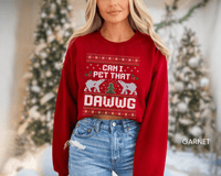 Thumbnail for A woman wearing a red sweater with a Christmas-themed design and text, standing in front of a Christmas tree.