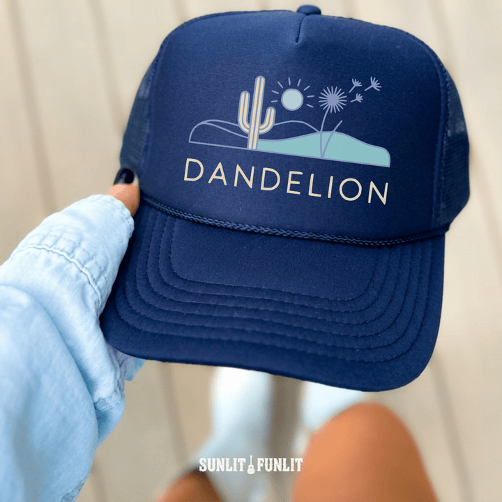 Navy blue cap with 'Dandelion' logo held by a person wearing a light blue jacket.