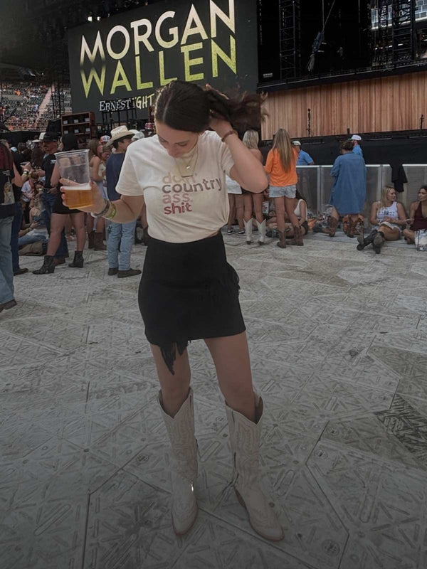 Person at a concert holding a drink with 'Wallen' branding in the background