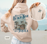 Thumbnail for A woman wearing a beige hoodie with a graphic design of a beach bar and tequila.