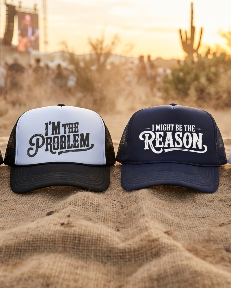 Four baseball caps with humorous text designs on a sandy background with people and cacti.