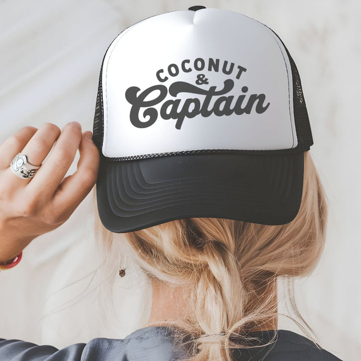 Person wearing a white and black cap with 'Coconut & Captain' text on a plain background