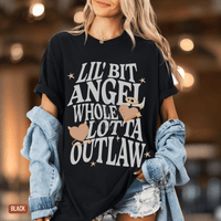 Thumbnail for A woman wearing a black t-shirt with white text and graphics, including hearts and stars, standing in a room with a blurred background.