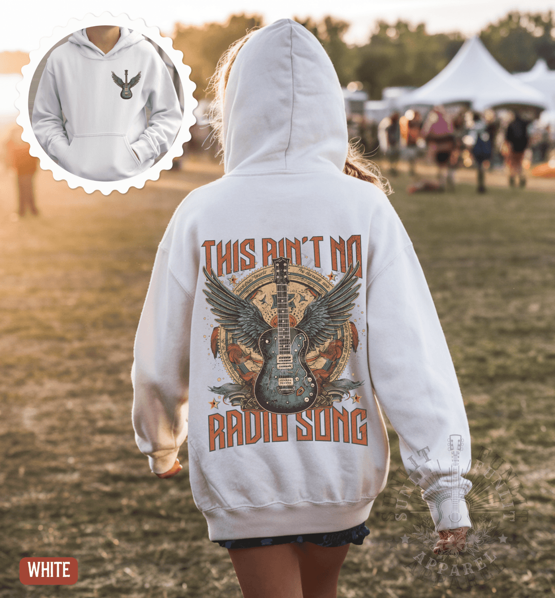 A person wearing a white hoodie with a graphic design of a guitar and wings, along with the text "This isn't no RADIO SONG".